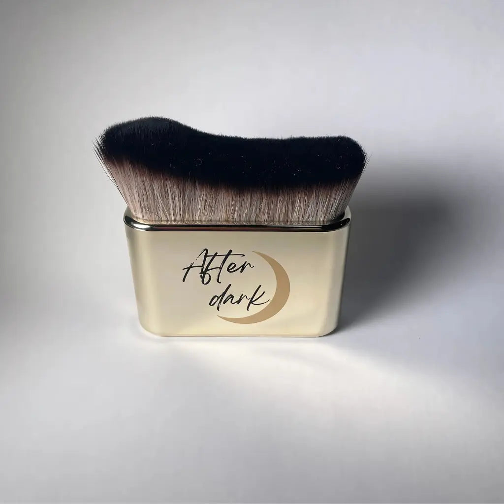 Tanning brush with soft bristles and a gold handle with the 'After Dark' logo.